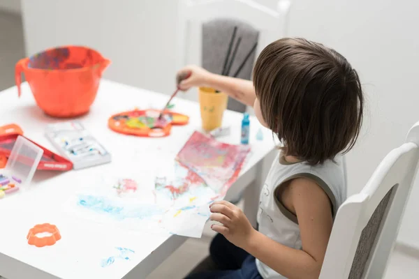 Menino em casa desenhando e brincando — Fotografia de Stock