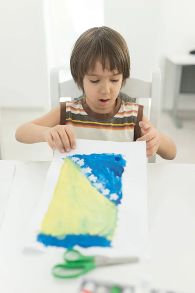 Маленький хлопчик вдома малює і грає — стокове фото