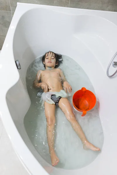 Little happy kid at home playing in bathroom having fun in batht — Stock Photo, Image