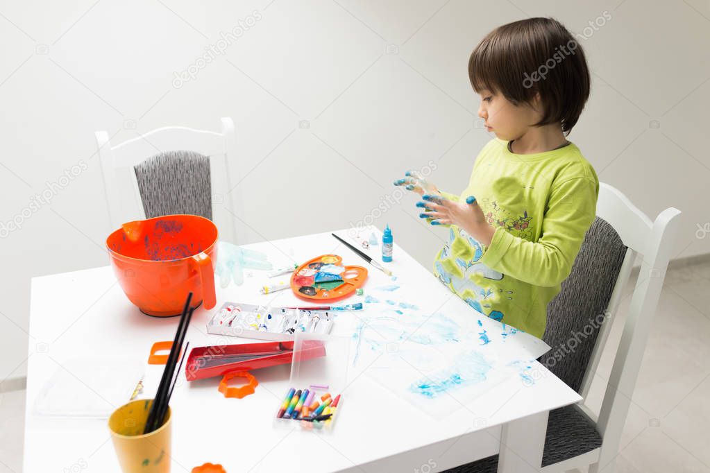 Little boy at home drawing and playing