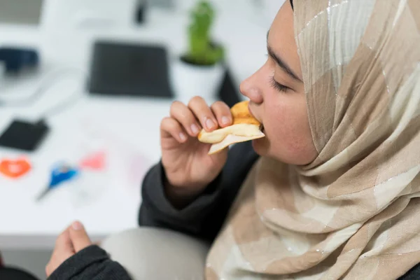 Μουσουλμανική εφηβικό κορίτσι σε εσωτερικούς χώρους, τρώγοντας σνακ — Φωτογραφία Αρχείου