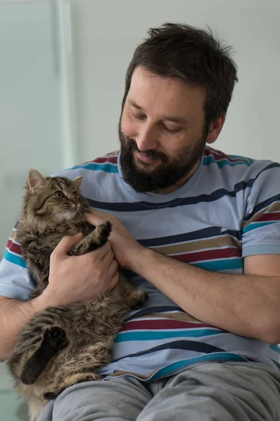 Dospělý muž s kočkou doma — Stock fotografie