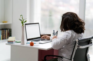 Genç erkek girişimci masada oturan ve dizüstü bilgisayarda çalışma sırasında çalışma