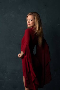 Hacimli kolları kısa bir kırmızı elbiseli uzun boylu ince sarışın