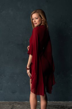 Hacimli kolları kısa bir kırmızı elbiseli uzun boylu ince sarışın