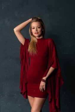 Hacimli kolları kısa bir kırmızı elbiseli uzun boylu ince sarışın