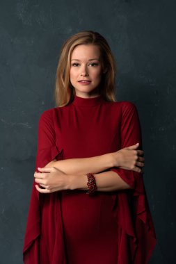 Hacimli kolları kısa bir kırmızı elbiseli uzun boylu ince sarışın