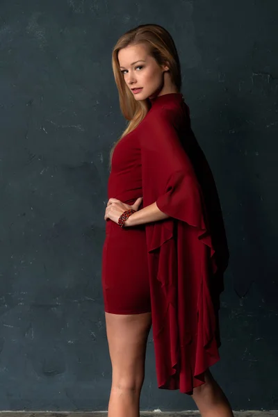 ゆったりした袖の短い赤いドレスを着た背の高い細いブロンド — ストック写真