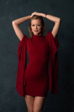 Hacimli kolları kısa bir kırmızı elbiseli uzun boylu ince sarışın