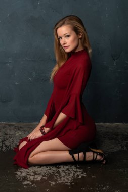 Hacimli kolları kısa bir kırmızı elbiseli uzun boylu ince sarışın