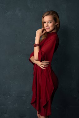 Hacimli kolları kısa bir kırmızı elbiseli uzun boylu ince sarışın