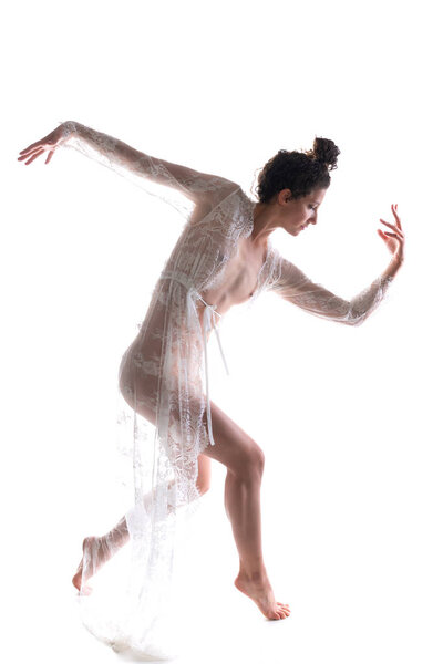 Tall slim brunette dancing in a sheer white lace wrap