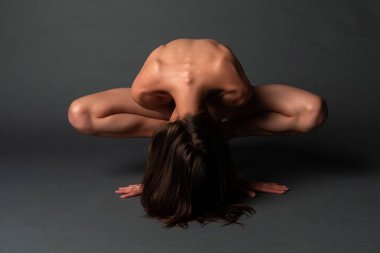 Gri bir arka plan üzerinde uzun boylu ince Ukraynalı esmer çıplak