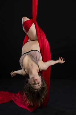 Petite atletik esmer acrobat kırmızı ipekten askıya