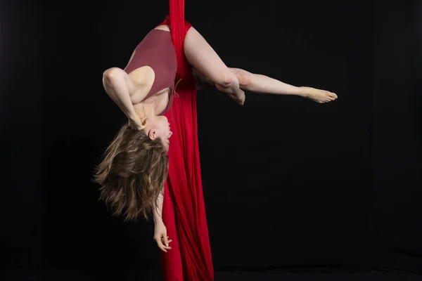 Brunette acrobat on red silk — Stock Photo, Image