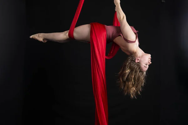 Brunette acrobat on red silk — Stock Photo, Image