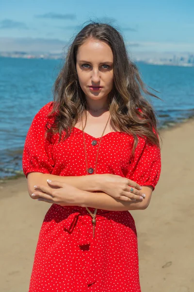 Brunette in red on a beach — Stock Photo, Image