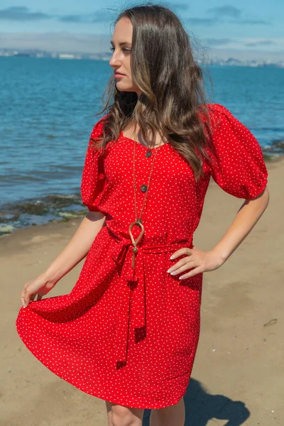 Morena en rojo en una playa — Foto de Stock