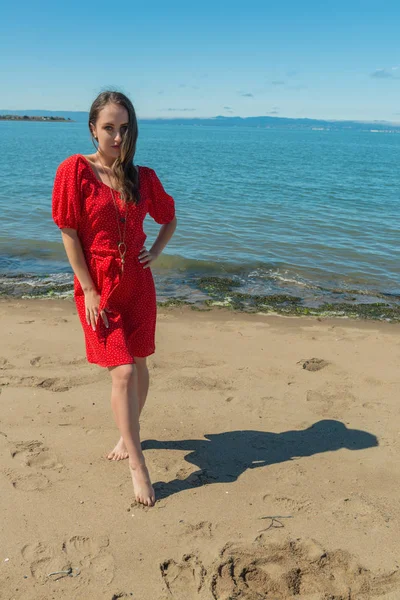 Μελαχρινή σε κόκκινο σε μια παραλία — Φωτογραφία Αρχείου