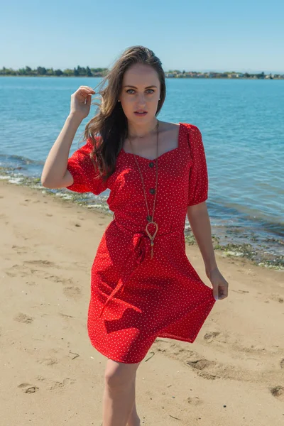 Брюнетка в червоному на пляжі — стокове фото