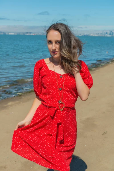 Brünette in rot auf ein strand — Stockfoto