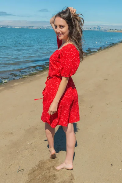 Brünette in rot auf ein strand — Stockfoto