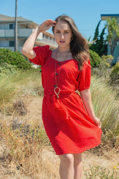 Brünette in rot auf ein strand — Stockfoto