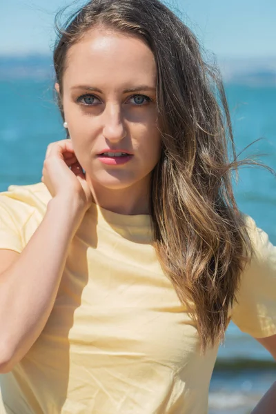Brunette in yellow by the bay — Stock Photo, Image
