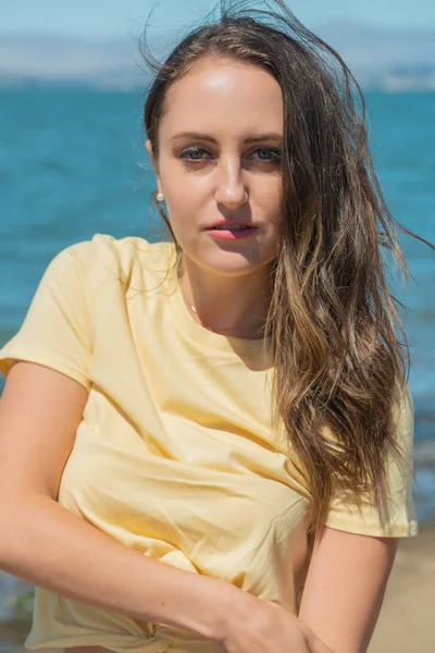 Brunette in yellow by the bay — Stock Photo, Image