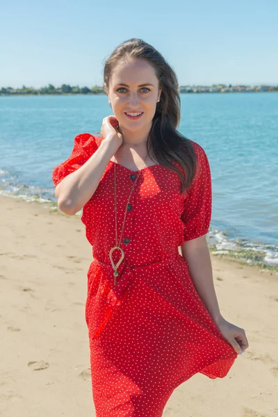 Morena en rojo en una playa — Foto de Stock