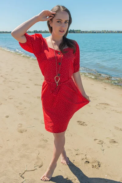 海滩上穿红红的布鲁内特 — 图库照片