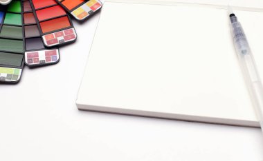 Beyaz desenli kağıt üzerinde fırça ile suluboya palet. 