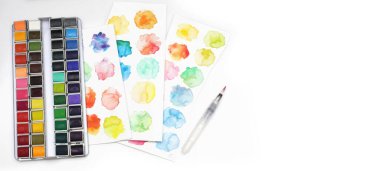 Suluboyalı kutu, arka planda fırça ve palet. Düz yatıyordu. Üst görünüm... yatay uzun pankart