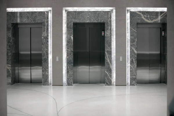 Three elevator entrances in an empty interior.