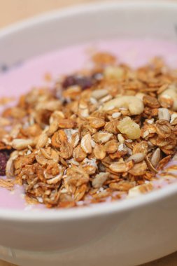 Sağlıklı kahvaltı. Fındık, tahıl, tohum, kuru üzüm, şekerli meyve ve süt yoğurdu.