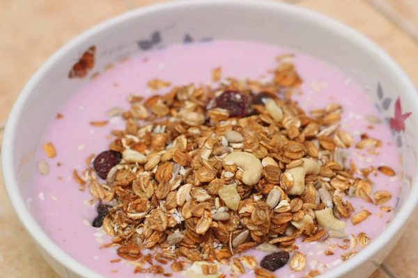 Sağlıklı kahvaltı. Fındık, tahıl, tohum, kuru üzüm, şekerli meyve ve süt yoğurdu.