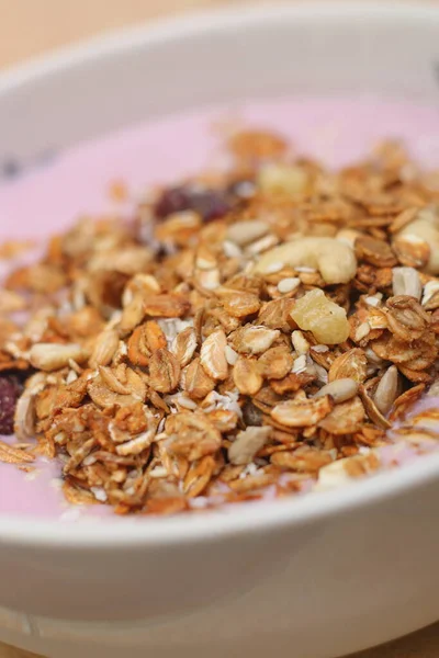 Sağlıklı kahvaltı. Fındık, tahıl, tohum, kuru üzüm, şekerli meyve ve süt yoğurdu.