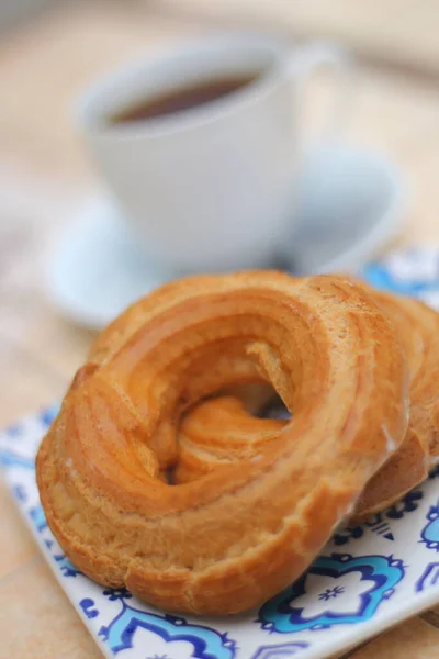 - Günaydın. Fincan tabağında porselen bir fincanda Espresso kahvesi. Kare bir tabakta kremalı pasta yüzüğü ve doğulu süsler.