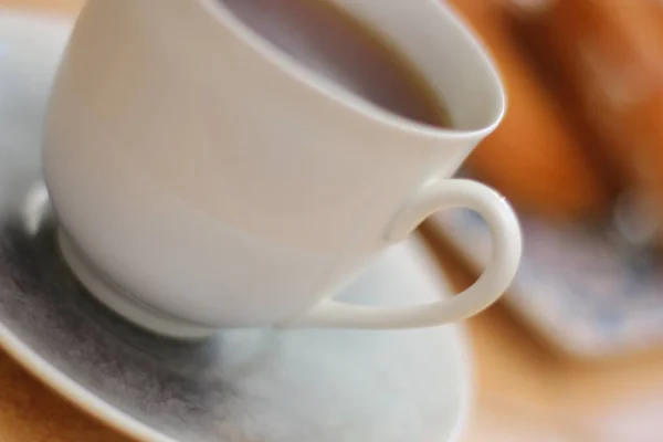 - Günaydın. Fincan tabağında porselen bir fincanda Espresso kahvesi. Kare bir tabakta kremalı pasta yüzüğü ve doğulu süsler.