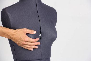 Erkek el hafifçe kadın dikiş yarı açık manken, gri arka plan, kopya alanı sağ göğsünü tutar 