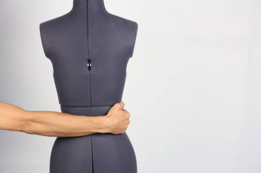 Erkek el hafifçe kadın dikiş manken kız, gri arka plan, kopya alanı olarak bel tutar 