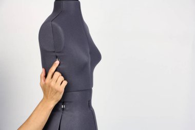 terzi bir plastik cerrah gibi el hafifçe ayar vidası, gri arka plan sıkma bir kadın dikiş manken üzerinde gövde genişliğini değiştirmek, alanı Kopyala 