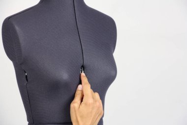 bir plastik cerrah değiştirmek gibi ayar vidası, gri arka plan, sıkma bir kadın dikiş yarı açık manken üzerinde meme boyutunu insan eli kopyalama alanı 