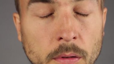 sakal ve bıyık hapşırma adamla sonra burnunu darbeler ve burun mavi mendil, yüz closeup, gri arka plan, ön görünüm ile mendil