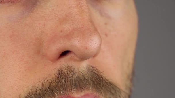 Чоловік Вусами Нюхає Носом Витирає Його Пальцями Сірий Фон Крупним — стокове відео