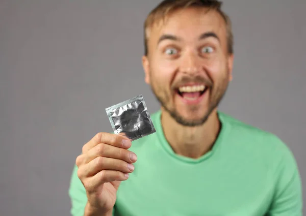 Człowiek Zielonej Koszuli Posiada Nowe Prezerwatywy Ręku Radość Znaleziono Prezerwatywę — Zdjęcie stockowe