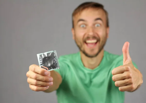 Pria Dengan Kemeja Hijau Memegang Kondom Baru Tangan Membuat Gerakan — Stok Foto