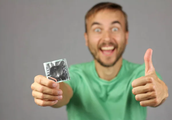 Uomo Camicia Verde Tiene Mano Nuovo Preservativo Fare Gesto Pollice — Foto Stock