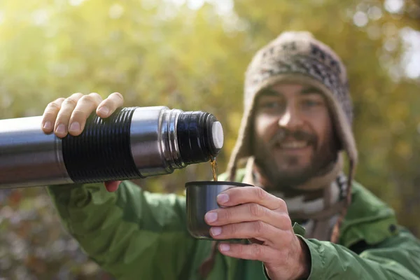 Muž Pletené Čepici Úsměvem Nalije Horký Nápoj Čaj Nebo Kafe — Stock fotografie