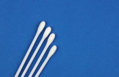 dört Beyaz pamuk temizleme bezi veya tomurcukları tedavi yaralar, mavi arka plan, ya da kişisel hijyen için yakın çekim